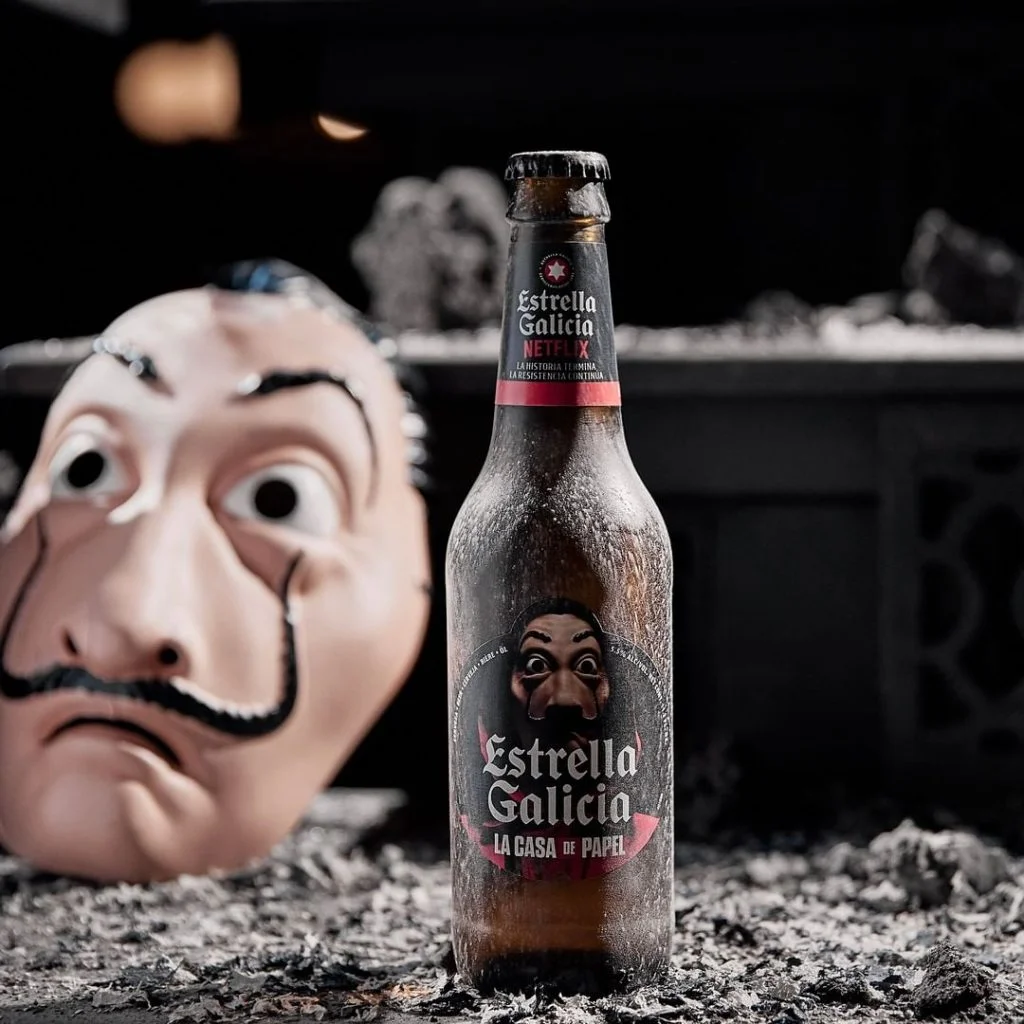 Botella Estrella Galicia Especial Edicion La casa de papel y detrás una mascara