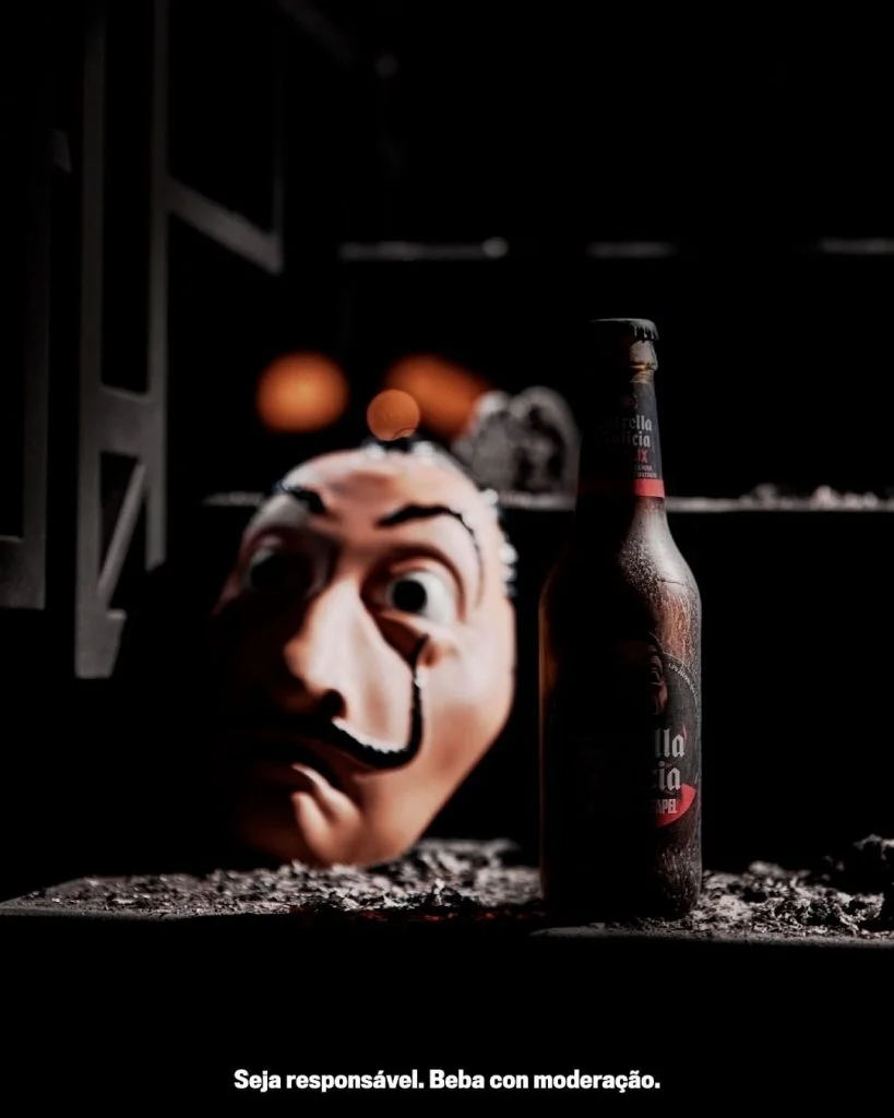 Botella Estrella Galicia Especial Edicion La casa de papel y detrás una mascara